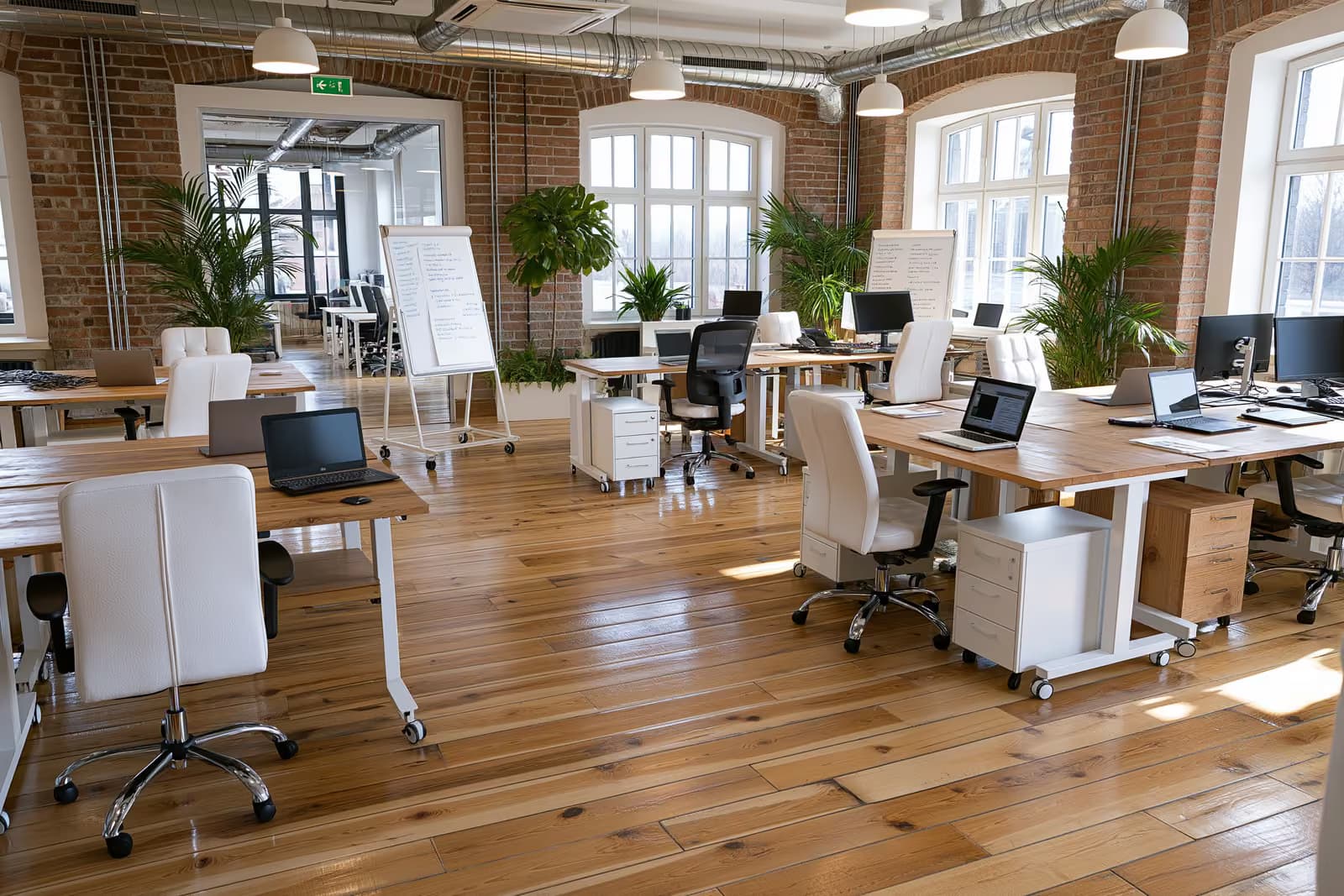 Themeluesit duke punuar së bashku në tavolina në një zyrë moderne gjermane të një startup-i.
